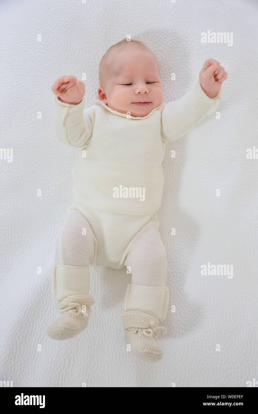 Top View Of A 2 Month Old Baby Waving His Arms Up In White Layette Lying On His Back Stock Photo Alamy