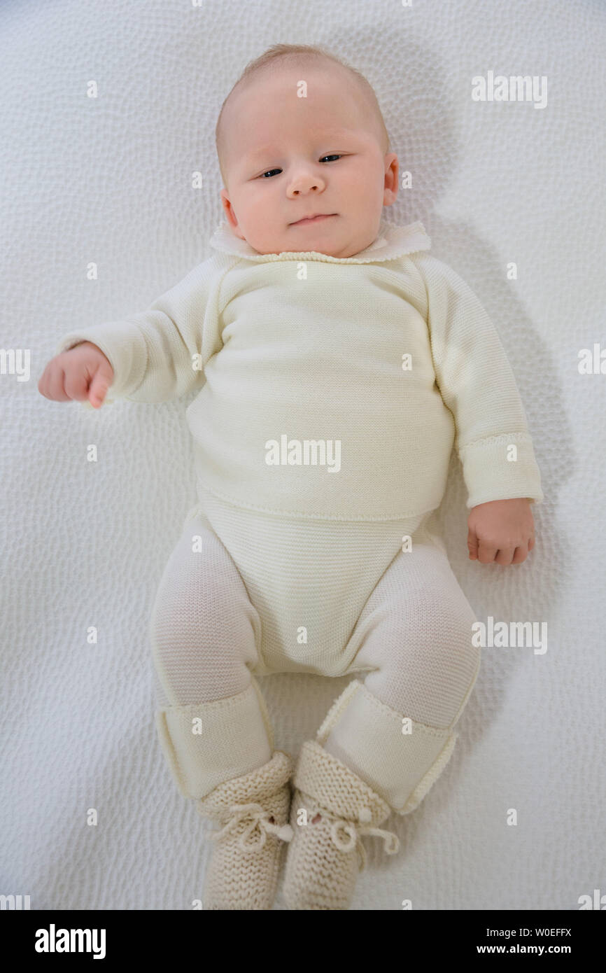 Top view of a baby of 2 months in white layette lying on the back. Stock Photo