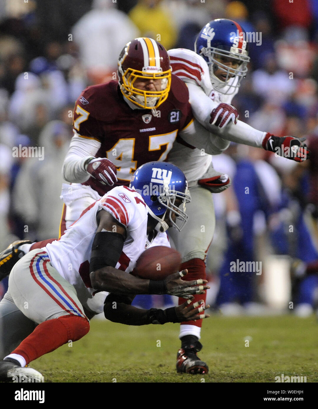 New York Giants safety James Butler (37) and line backer Antonion Pierce  (58) break up a pass intended for Washington Redskins Chris Cooley during  the fourth quarter at FedEx Field in Landover,