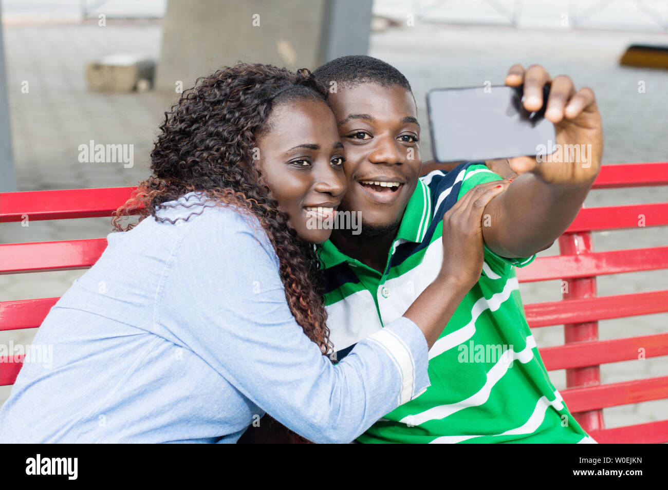 young couple takes pictures to mark their ride in the public square. Stock Photo