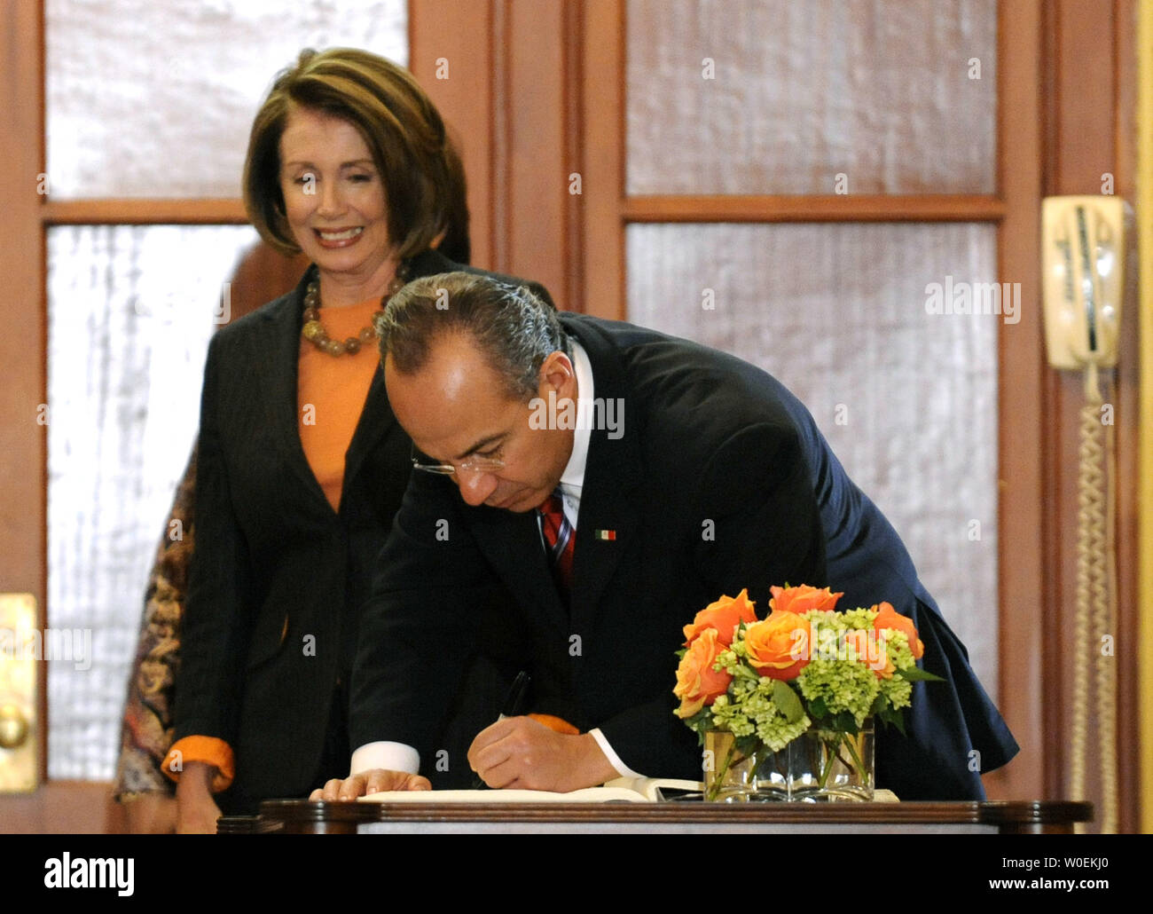 Mexican President Felipe Calderon signs a guest book as Speaker of the House Nancy Pelosi watches on, prior to a meeting on Capitol Hill in Washington on January 12, 2008. (UPI Photo/Kevin Dietsch) Stock Photo