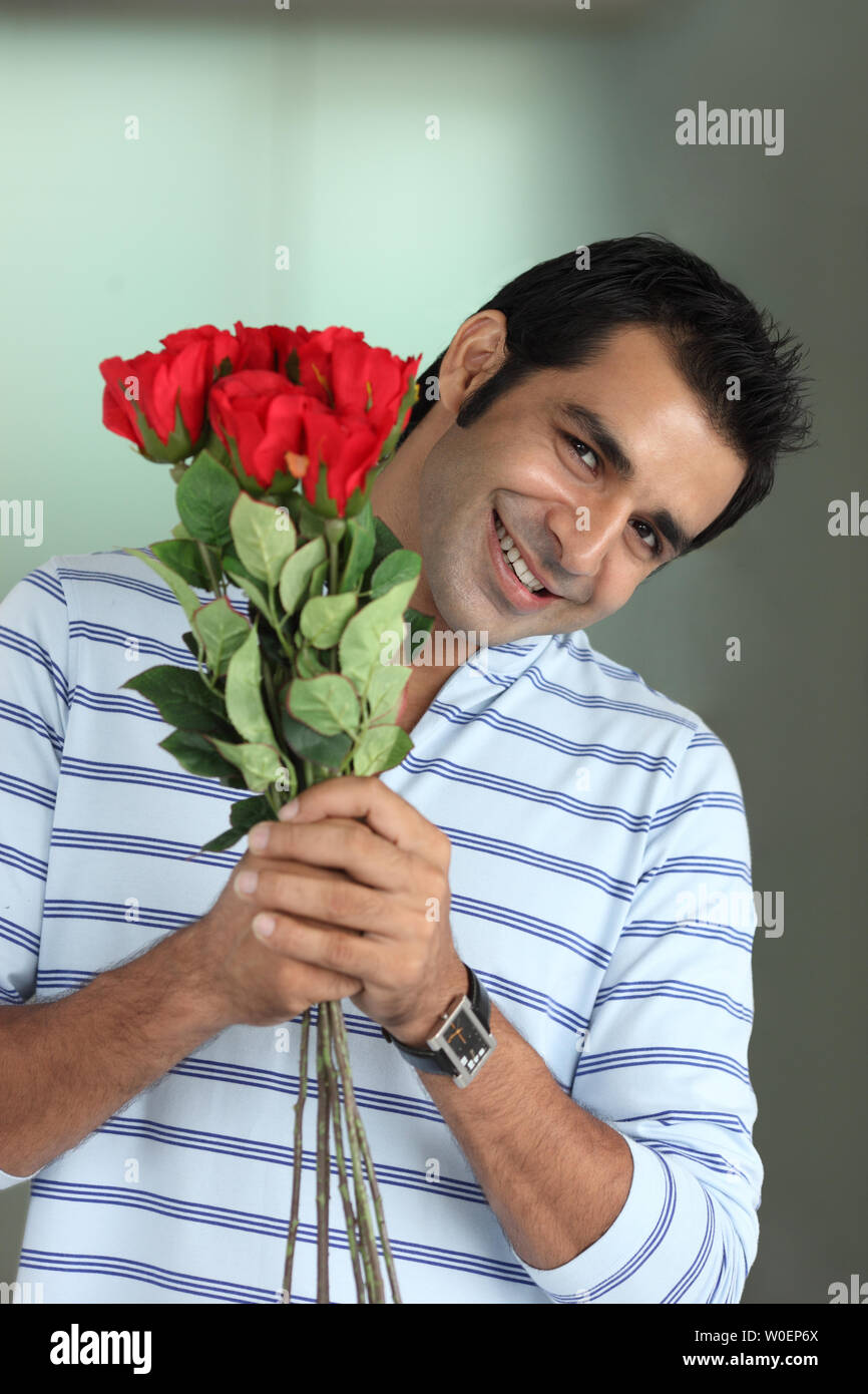 Portrait of a man holding bunch of flowers and smiles Stock Photo - Alamy
