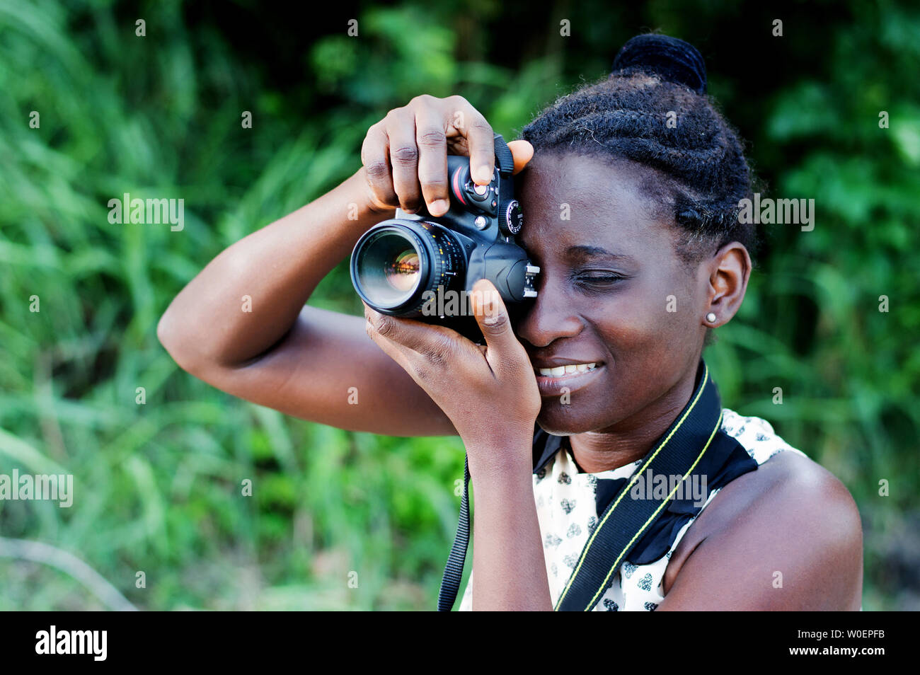 Travel, tourism and hobby. Young woman photographer taking pictures in the bush. Stock Photo