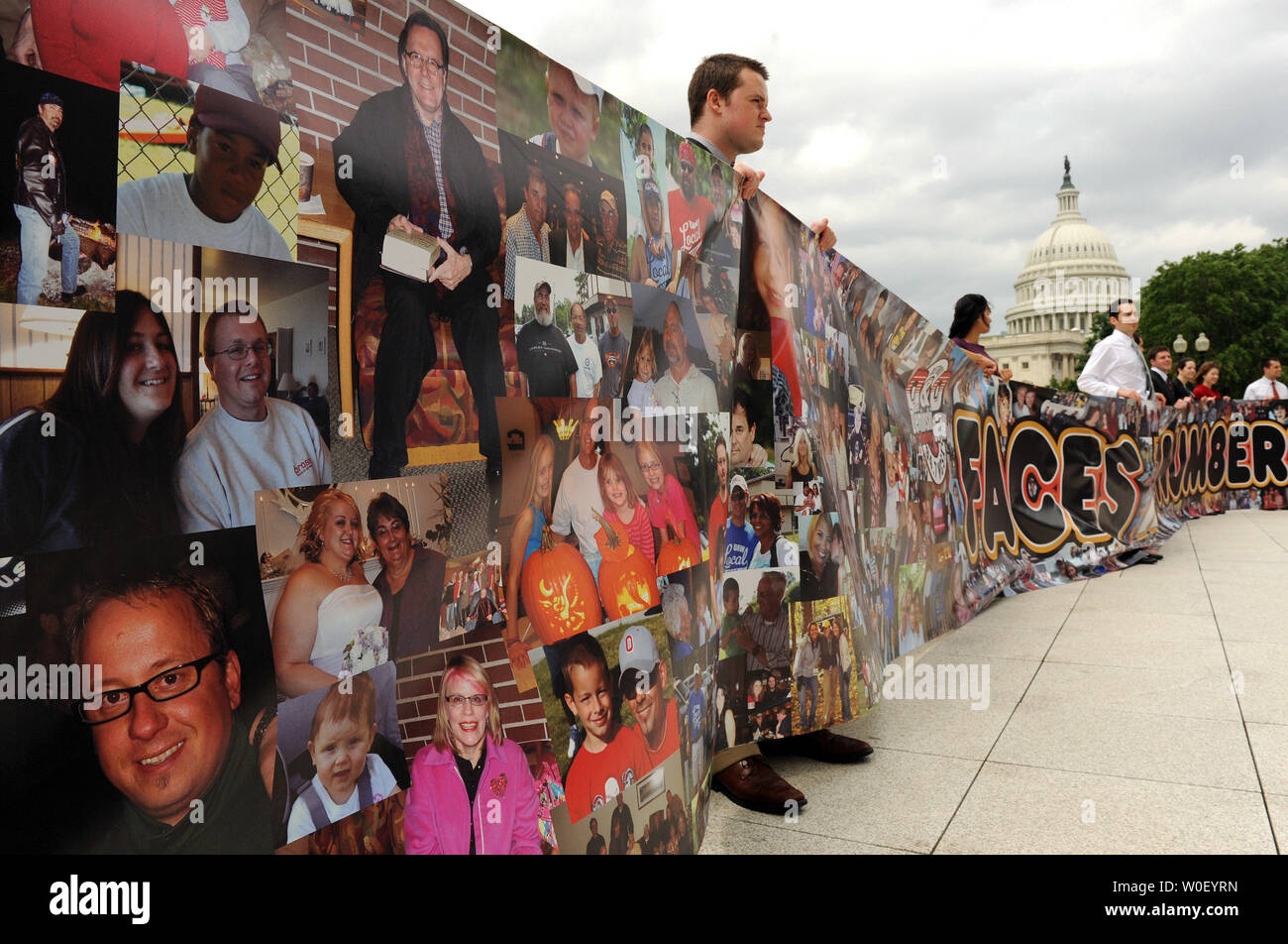 Volunteers hold a banner over 100 feet long with more than 4,000 photos of Americans affected by downturn in the auto industry on Capitol Hill in Washington on May 14, 2009. The banner is part of the 'Faces Not Numbers' campaign started by Detroit radio station WCSX 94.7.    (UPI Photo/Roger L. Wollenberg) Stock Photo