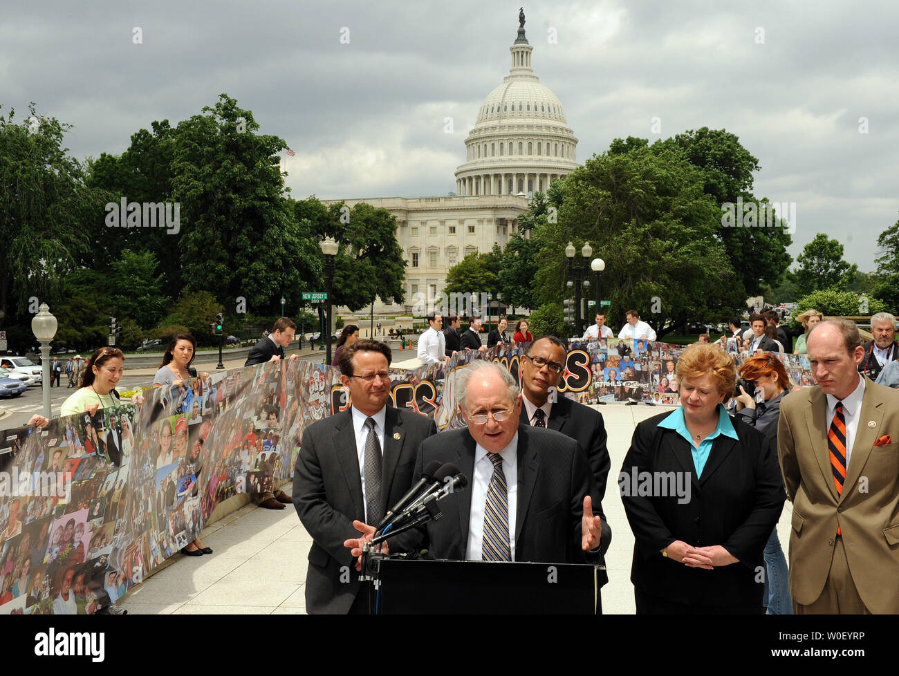 Sen. Carl Levin, D-MI, speaks as volunteers hold a banner over 100 feet long with more than 4,000 photos of Americans affected by downturn in the auto industry on Capitol Hill in Washington on May 14, 2009. The banner is part of the 'Faces Not Numbers' campaign started by Detroit radio station WCSX 94.7. From left are Rep. Gary Peters, R-MI, Levin, un unidentified man, Sen. Debbie Stabenow, D-MI, and Rep. Thaddeus McCotter, R-MI.      (UPI Photo/Roger L. Wollenberg) Stock Photo