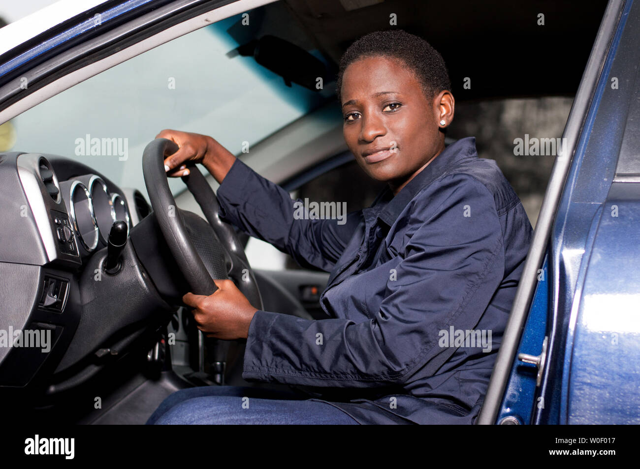 Beautiful young woman sitting at the wheel and looking at the camera. Stock Photo