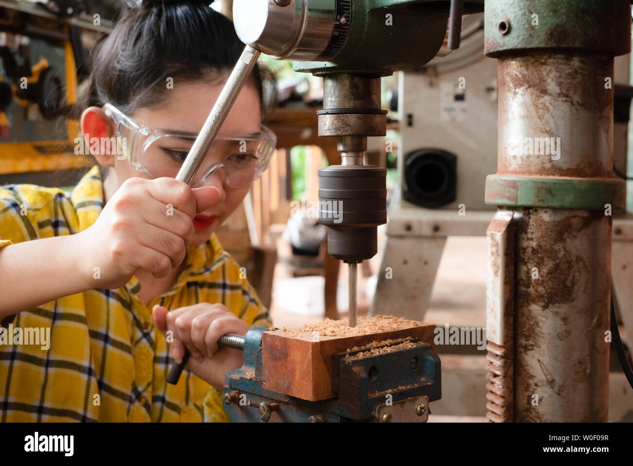 Women Standing Is Craft Working Drill Wood At A Work Bench With