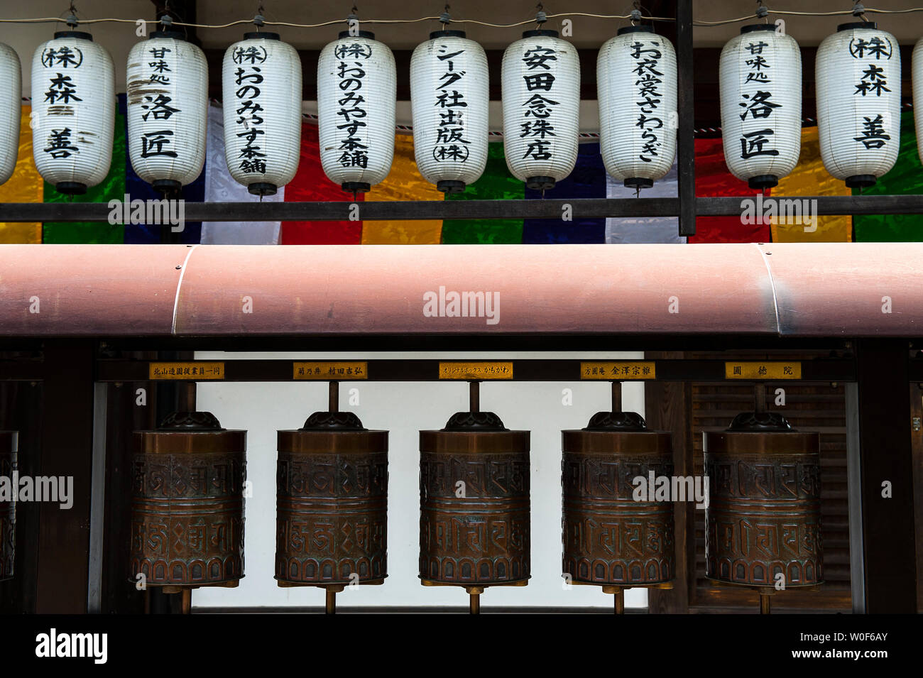 Prayer mills and chinese lanterns in a row at Ryozen temple, kyoto