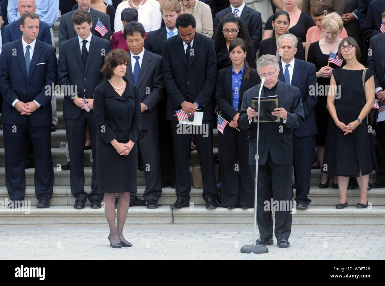 Reverend Daniel P. Coughlin (R), Chaplain of the U.S. House of Representatives, says a prayer while widow of Senator Edward Kennedy, Vicki Kennedy (L) and members of Congress and former and current staff members of the Senator listens, outside the U.S. Capitol building in Washington on August 29, 2009. Senator Kennedy, who passed away August 25 at the age of 77, will be buried  today at Arlington National Cemetery. UPI/Alexis C. Glenn Stock Photo