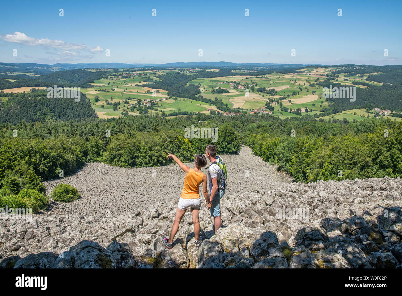 Auvergne - Rhone-Alpes - Haute-Loire - Saint-Julien-d'Ance - A couple on the Bourianne lava flow watching the view over the whole plain. Stock Photo