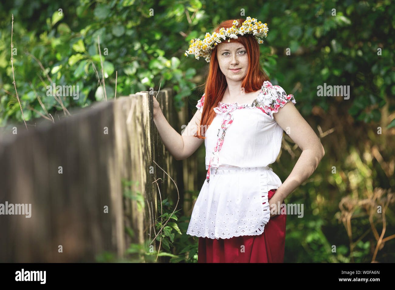 Red-haired woman in the countryside in a traditional outfit Stock Photo