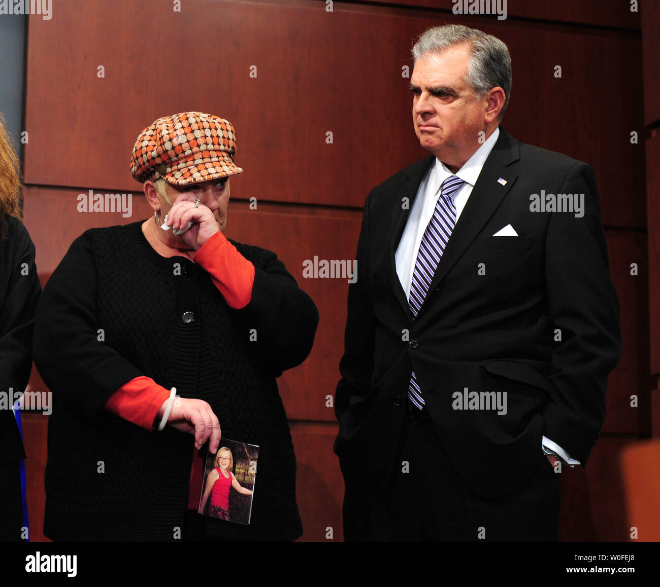 Transportation Secretary Ray LaHood (L) stands next to Elissa Schee as she wipes tears from her eyes, holding a photo of her daughter Margay, 13, who was killed when a distracted semi truck driver crashed into her school bus, during a press conference on distracted driving at the Transportation Department in Washington on January 12, 2010. LaHood introduced a new non-profit anti-distracted driving program called Focus Driven Initiative. UPI/Kevin Dietsch Stock Photo