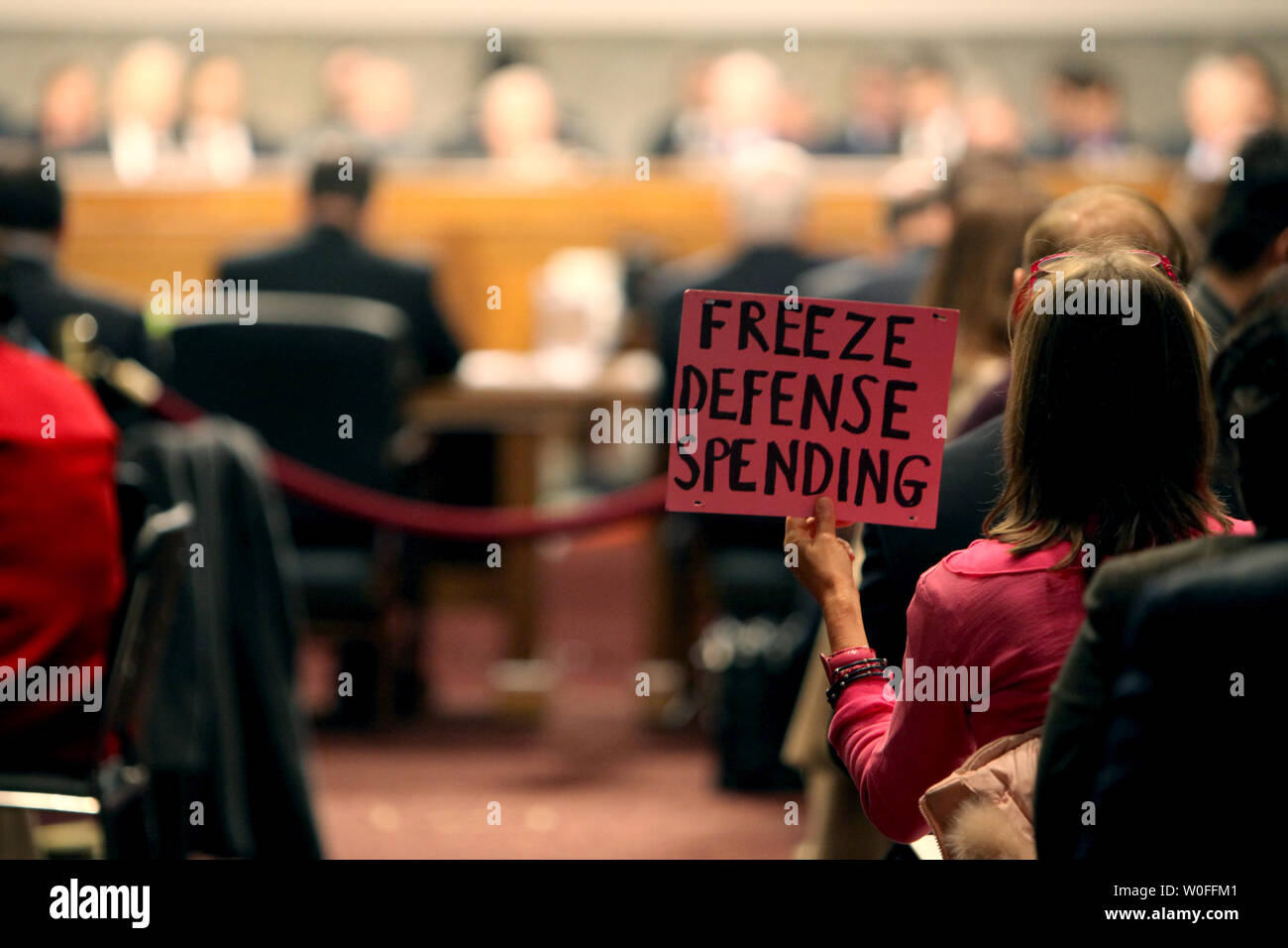A Code Pink protester holds a sign saying 'Freeze Defense Spending' during a full Senate Armed Services Committee hearing on the Defense Authorization Request for FY2011 and the 'Don't Ask, Don't Tell' policy on Capitol Hill in Washington February 2, 2010. Secretary of Defense Robert Gates and Chairman of the Joint Chiefs of Staff Adm. Michael Mullen testify.        UPI/Madeline Marshall Stock Photo