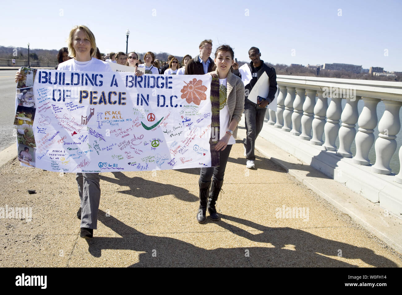 Demonstrators Carry Signs While Marching On The Memorial Bridge