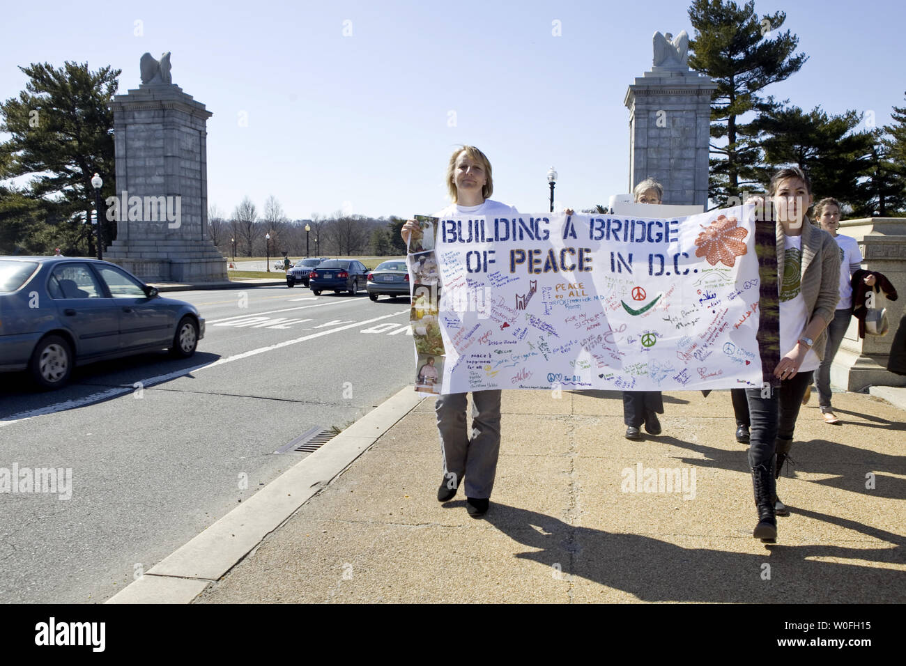 Demonstrators Carry Signs While Marching On The Memorial Bridge
