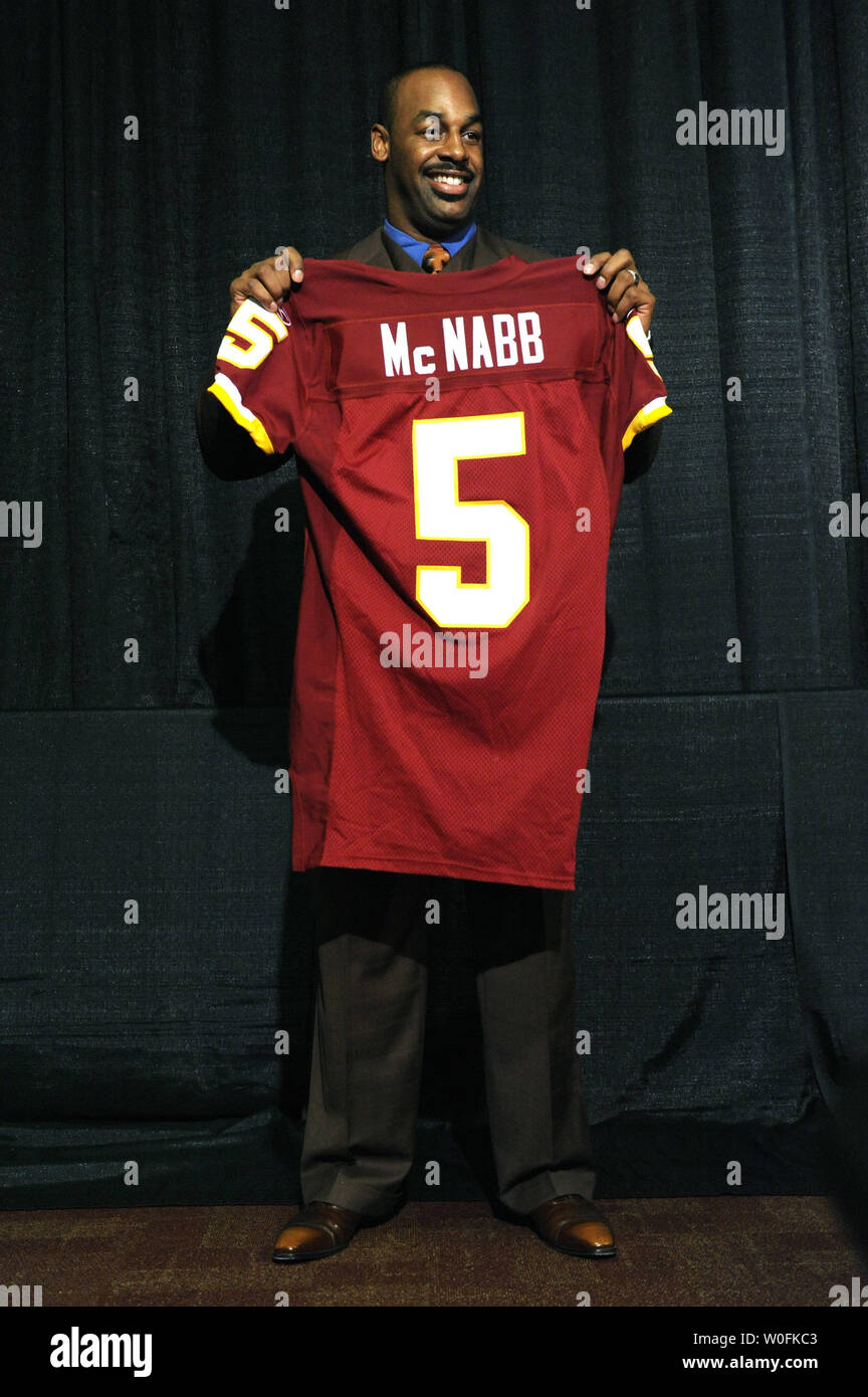 Washington Redskins new quarterback Donovan McNabb holds a jersey, after  head coach Mike Shanahan introduced McNabb to the team, at a press  conference at Redskins Park in Ashburn, Virginia on April 6