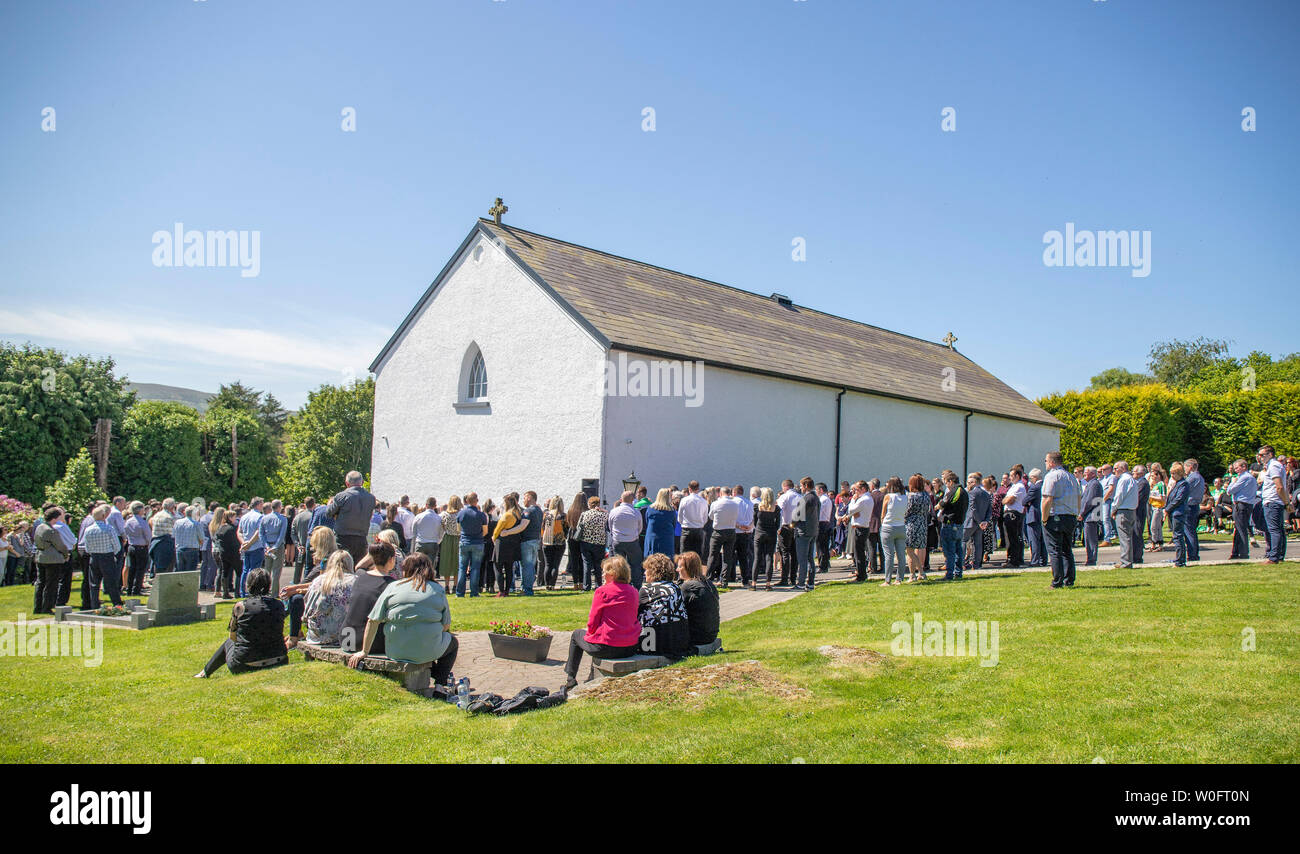 Mourners outside St Columba's Church in Glenswilly, County Donegal, for the funeral of rally driver Manus Kelly. Stock Photo