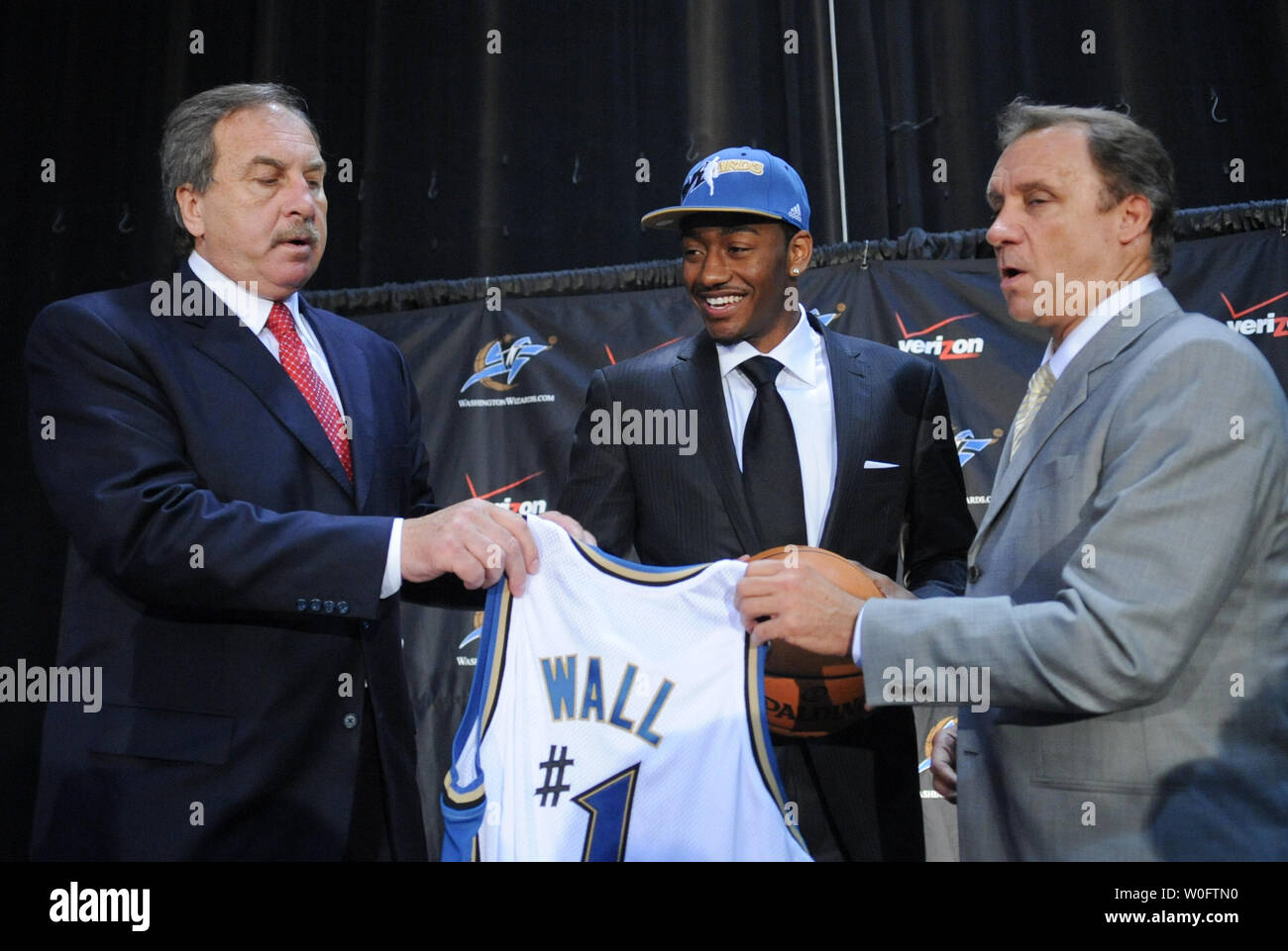 John Wall C the NBA 1 draft pick by the Washington Wizards holds a Wizards jersey alongside Wizards President Ernie Grunfeld L and Head Coach Flip Saunders at a press conference at