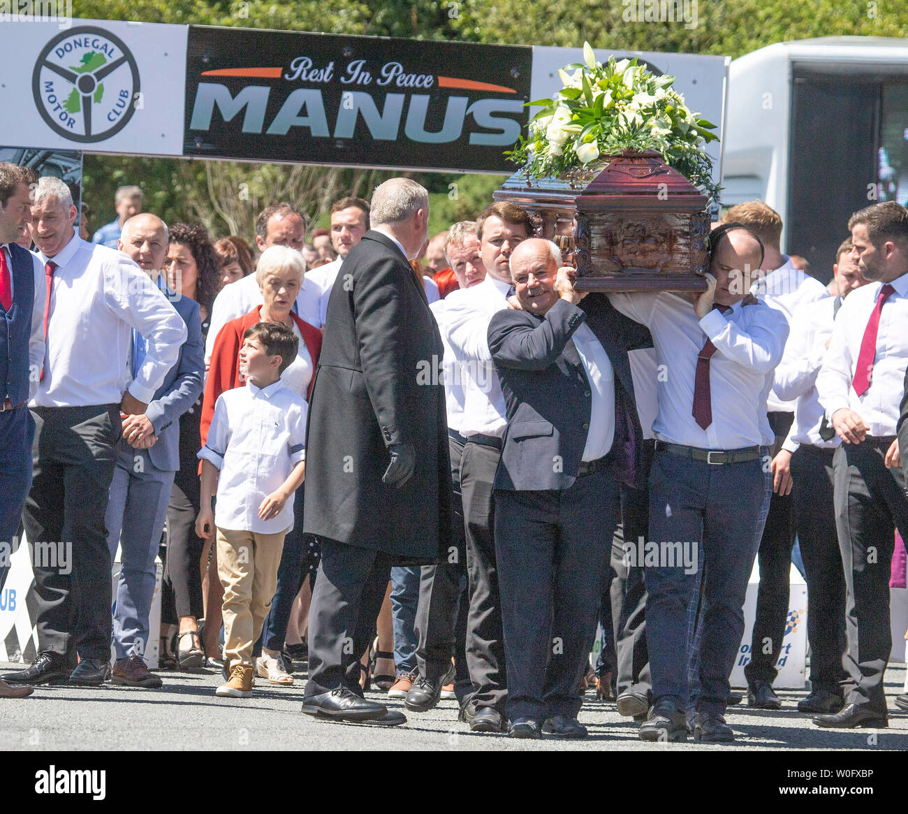 The coffin of rally driver Manus Kelly is taken from St Columba's Church in Glenswilly, County Donegal, to his final resting place. Stock Photo