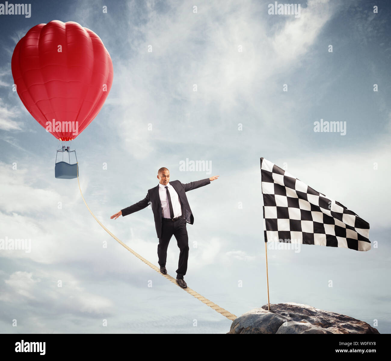 Business concept of businessman who overcome the problems reaching the flag on a rope Stock Photo