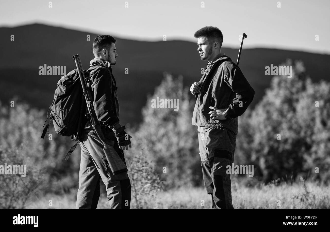 Friendship of men hunters. Military uniform. Army forces. Camouflage. Hunting skills and weapon equipment. How turn hunting into hobby. Man hunters with rifle gun. Boot camp. Hunter with weapon. Stock Photo