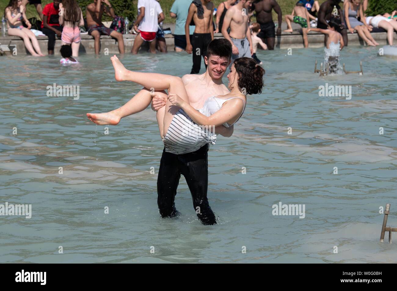 Paris, France. 26th June, 2019. People cool themselves at the fountain near Trocadero Square in Paris, France, June 26, 2019. A high-pressure system bringing hot air up from the Sahara is making temperatures climb to unusually level in France where hotspots of up to 40 degrees Celsius are forecast to hit Paris and most French cities this week, forcing the government to raise vigilance and trigger heatwave alert system. Credit: Jack Chan/Xinhua/Alamy Live News Stock Photo