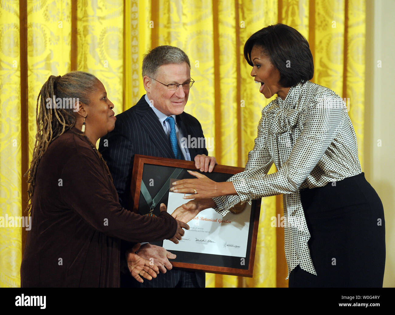 First Lady Michelle Obama presents a 2010 National Medal for Museum and Library Service to community member Karen Washington and Gregory Long, president and CEO of the New York Botanical Garden in New York City, during a ceremony in the East Room of the White House  in Washington on December 17, 2010.   UPI/Roger L. Wollenberg Stock Photo