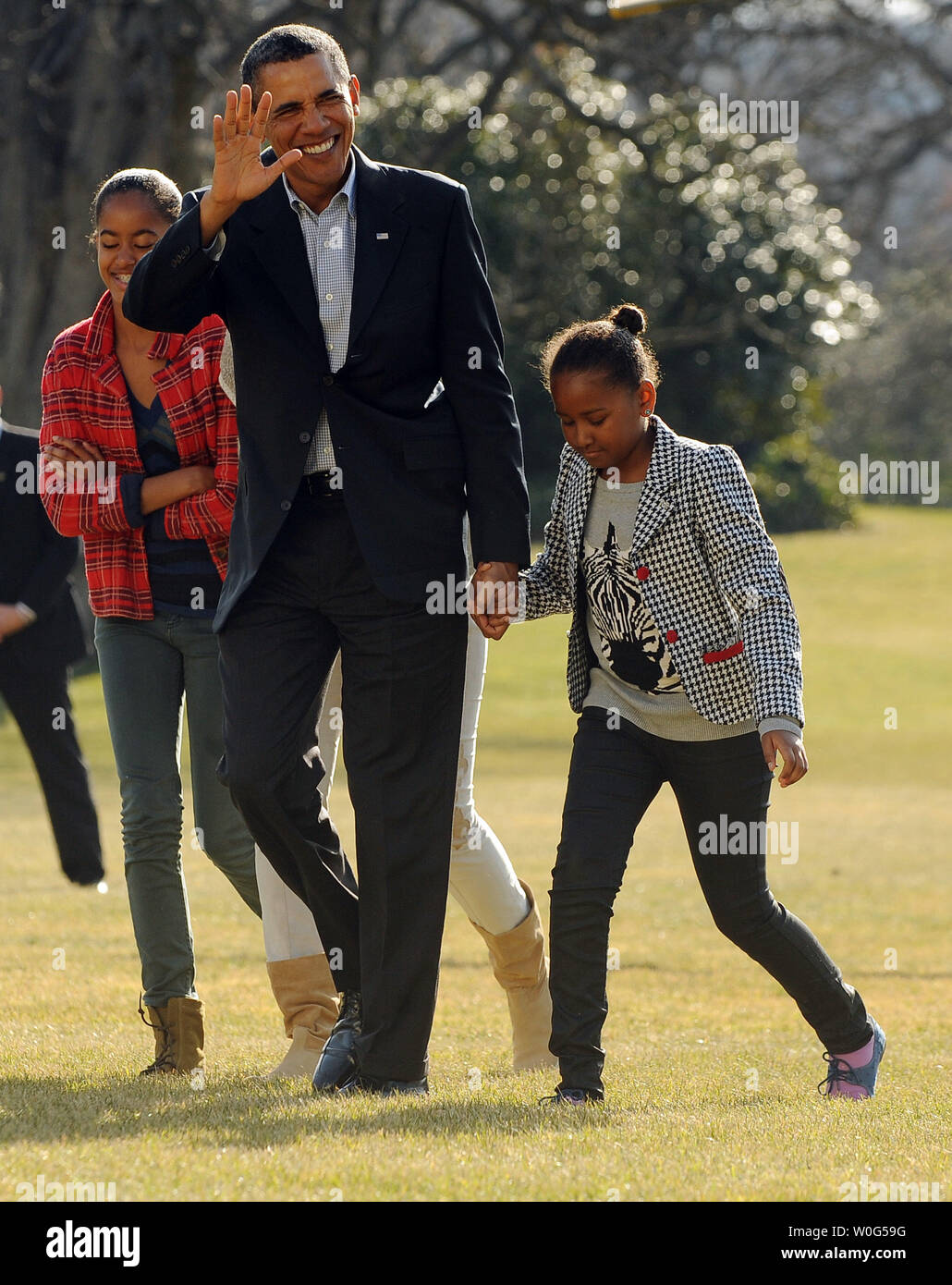 U.S. President Barack Obama, holding Sasha's hand while Malia laughs