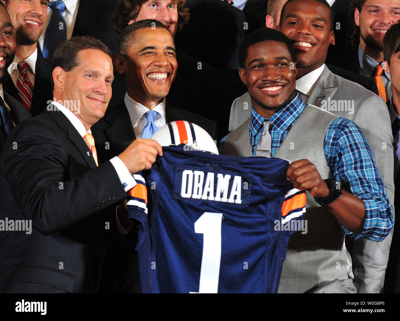 President Barack Obama is presented an Auburn University football jersey by Auburn  coach Gene Chizik and wide receiver Kodi Burns during a ceremony honoring  the 2010 NCAA Champion Auburn Tigers in the