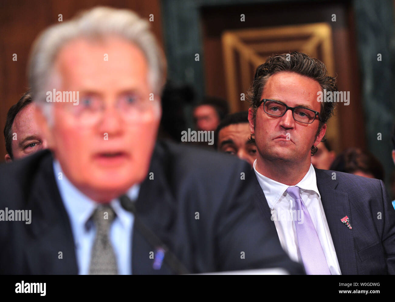 Actor Matthew Perry looks on as actor Martin Sheen testifies before a Senate Judiciary Committee Crime and Judiciary Subcommittee hearing titled 'Drug and Veterans Treatment Courts: Seeking Cost-Effective Solutions for Protecting Public Safety and Reducing Recidivism,' on Capitol Hill in Washington, D.C. on July 19, 2011.  UPI/Kevin Dietsch Stock Photo