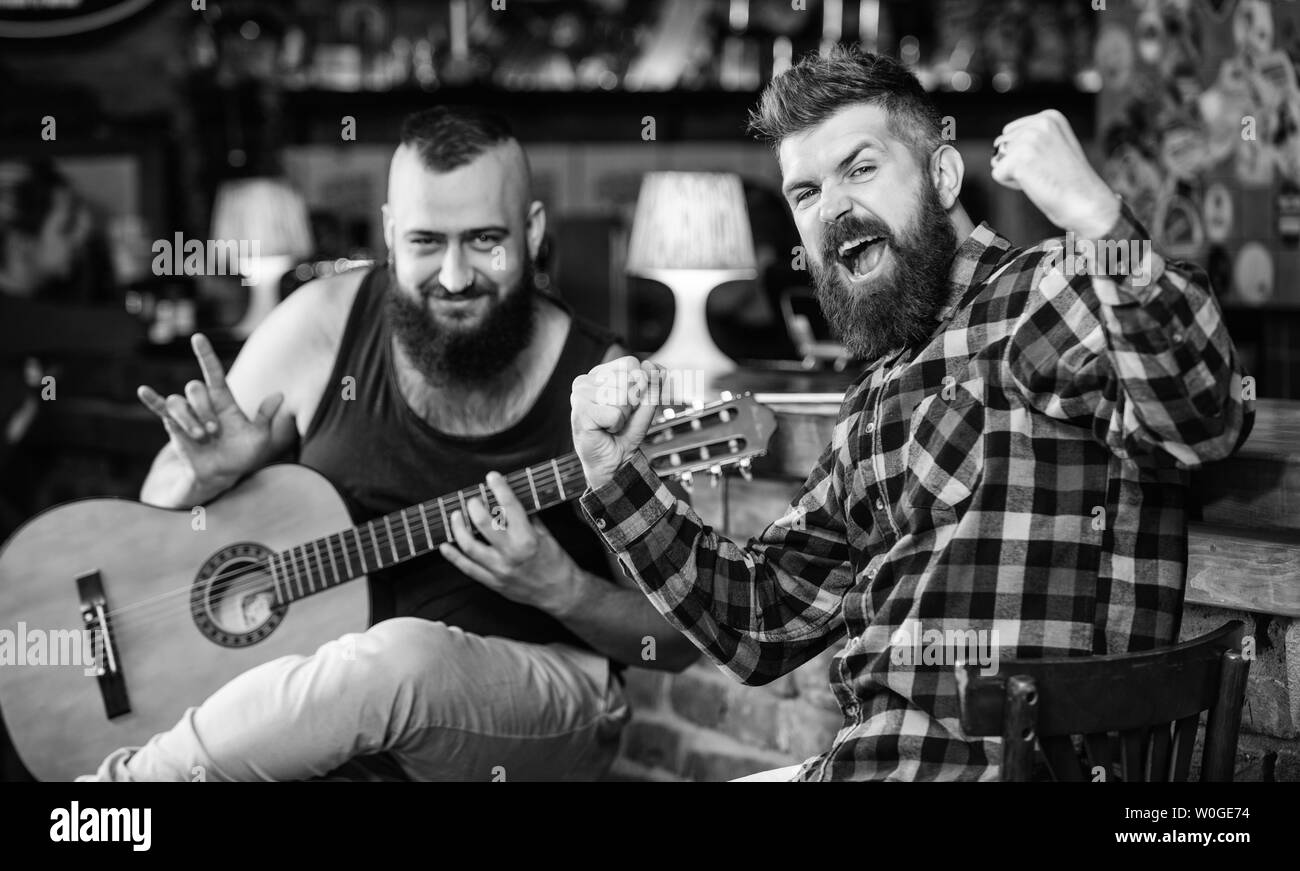Friends relaxing in pub. Live music concert. Man play guitar in pub. Acoustic performance in pub
