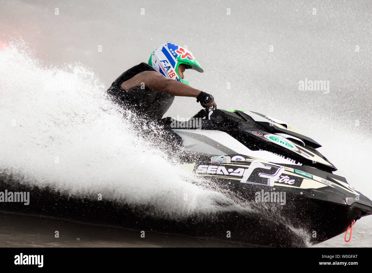 jet ski racer at Jet ski pro tour #3, Udonthani, Thailand - May 25, 2019 :Young man professional jet ski rider performs many tricks on the waves. Stock Photo