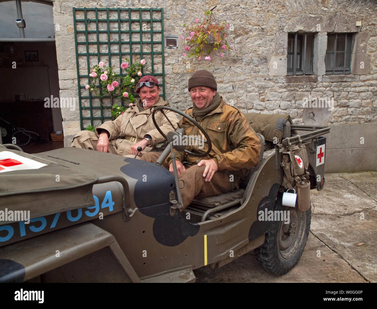 World War II historical reenactment enthusiasts sit in a vintage army jeep in Normandy Stock Photo