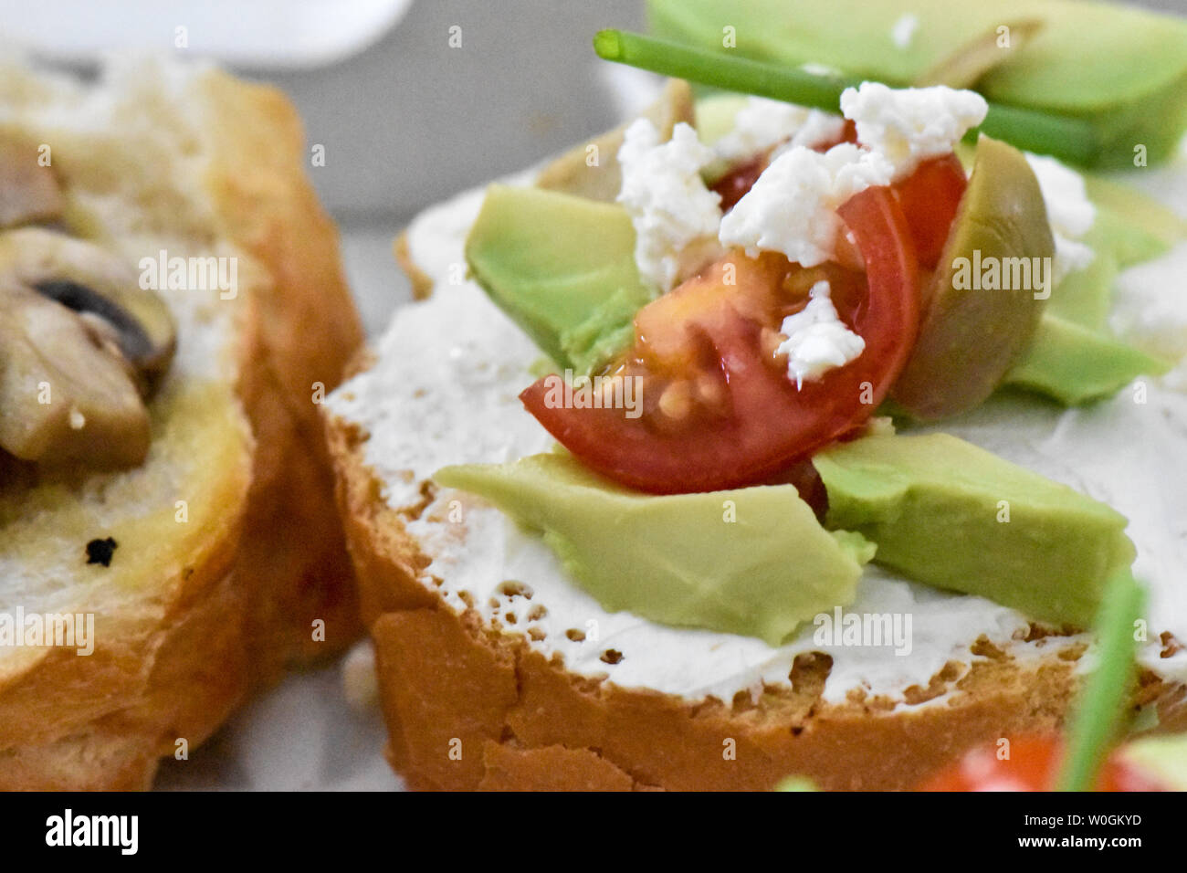 Clean living, Healthy snacking Avocado, tomato,mushroom and figs ready to be served with herbs, leaves and a small piece of french bread. Ideal bite Stock Photo