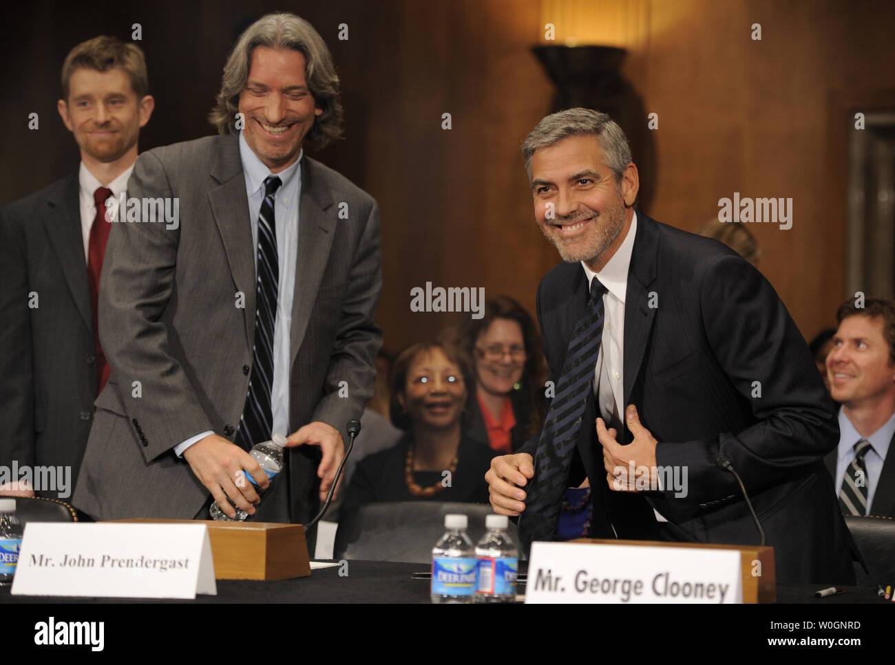 Actor George Clooney (R) takes his seat as he prepares to testifiy on Sudan before the Senate Foreign Relations Committee, along with human rights activist John Prendergast (C) and US Institute of Peace's Jonathan Temin (L), March 14, 2012, on Capitol Hill in Washington, DC. Clooney called for more international pressure on Khartoum to stop military action against civilians in the new state of South Sudan.   UPI/Mike Theiler Stock Photo