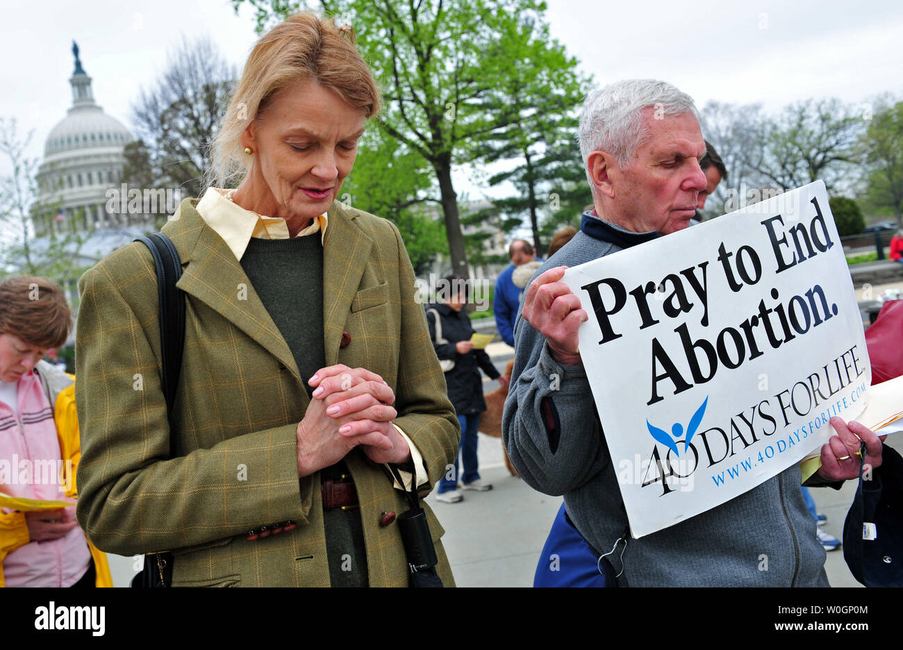 People pray in front of the United States Supreme Court during a rally against abortion a day before the Court will take up arguments on the constitutionality of President Obama's health care reform bill, in Washington, D.C. on March 25, 2012.   UPI/Kevin Dietsch Stock Photo