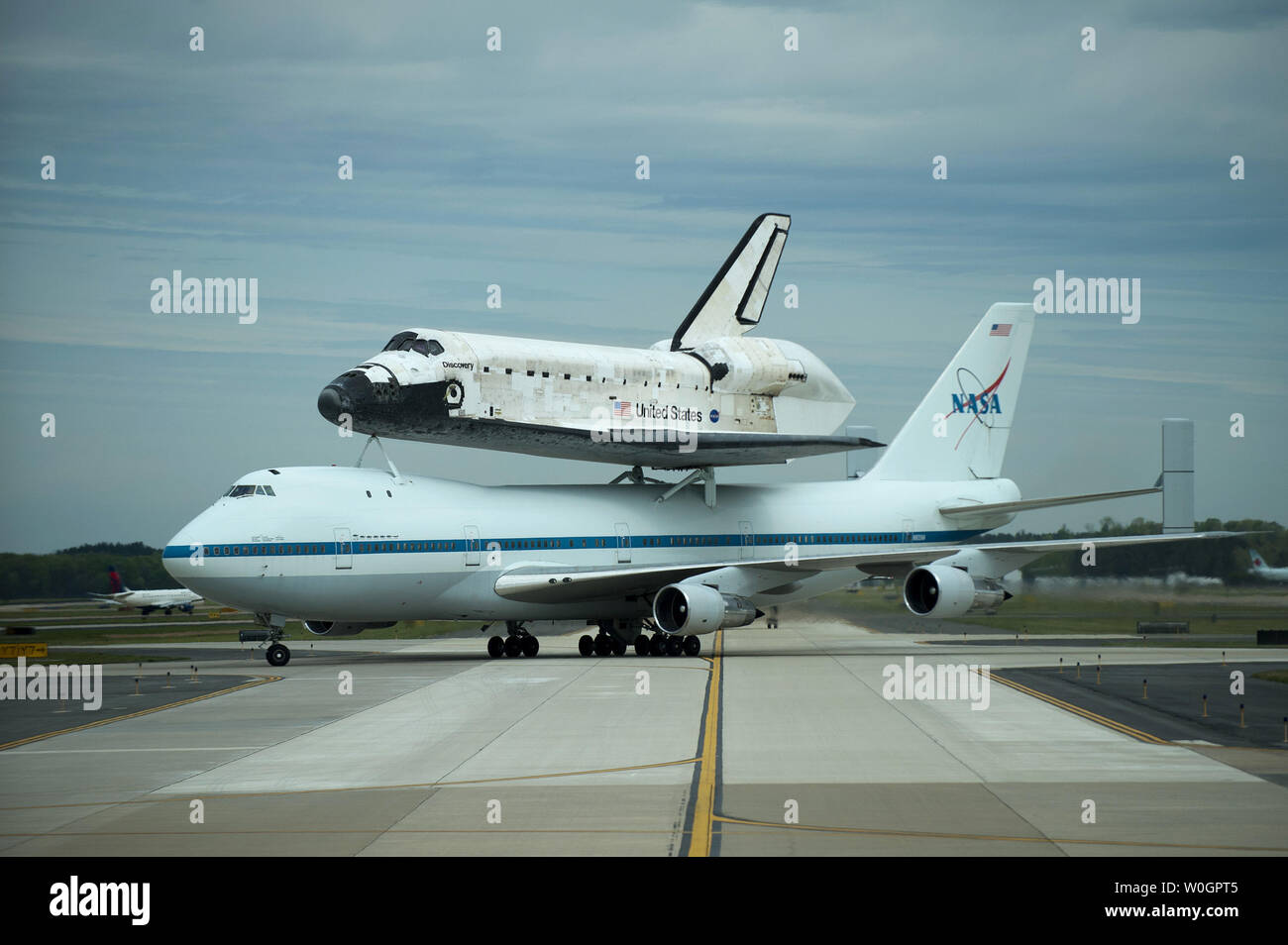 Space Shuttle Discovery, riding atop NASA's 747 shuttle carrier aircraft, taxis on the runway after landing at Dulles International Airport in Chantilly, Virginia on April 17, 2012.  Discovery, which ended it's last mission on March 9, 2011, is being put on permanent display at the Smithsonian's National Air and Space MuseumÍs Udvar-Hazy Center in Chantily, Virginia.  UPI/Kevin Dietsch Stock Photo