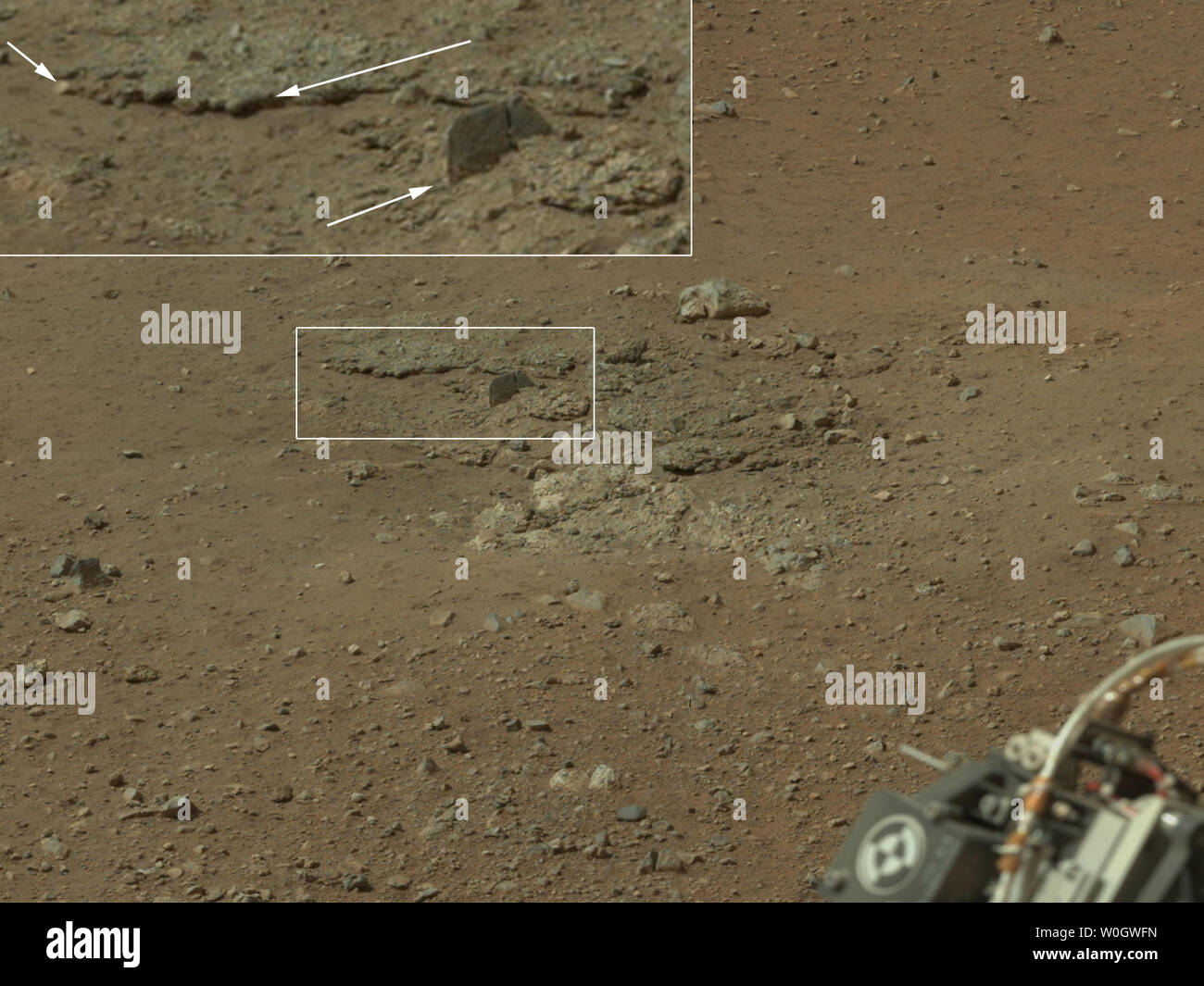This color image from NASA's Curiosity rover shows an area excavated by the blast of the Mars Science Laboratory's descent stage rocket engines. This is part of a larger, high-resolution color mosaic made from images obtained by Curiosity's Mast Camera on August 9, 2012 EDT.   Shown in the inset in the figure are pebbles up to 1.25 inches (about 3 centimeters) across (upper two arrows) and a larger clast 4 inches (11.5 centimeters) long protruding up by about 2 inches (10 centimeters) from the layer in which it is embedded.   UPI/NASA/JPL-Caltech/MSSS Stock Photo
