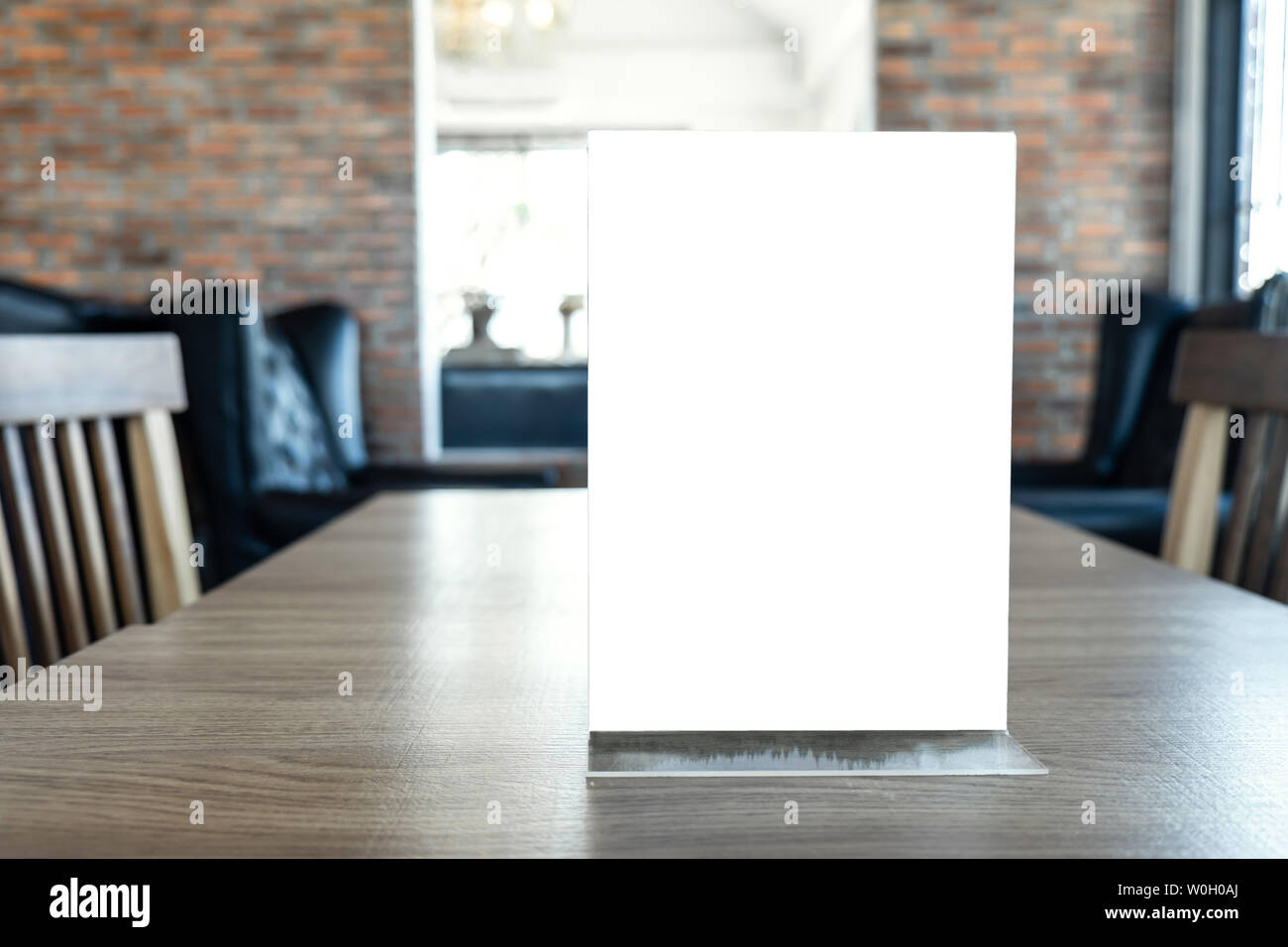 Blank screen mock up menu frame standing on wood table in coffee cafe and restaurant background. Stock Photo
