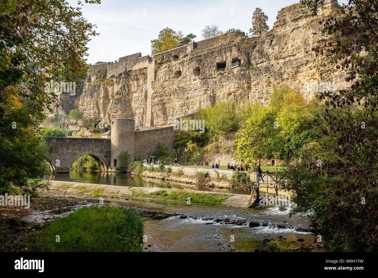 LUXEMBOURG CITY, LUXEMBOURG - OCTOBER 20, 2018: People relaxing beside Alzette river. Grund district, Luxembourg City Stock Photo