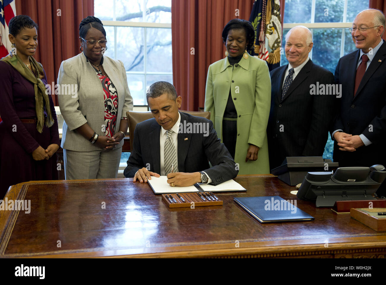 President Barack Obama signs a bill designating the Harriet Tubman Underground Railroad, in Maryland, a National Monument during a bill signing ceremony in the Oval Office at the White House on March 25, 2013 in Washington, D.C. President Obama signed a series of bills designating five new National Monuments, including, Rio Grande del Norte, in New Mexico, the First State Monument in Delaware, the Harriet Tubman Underground Railroad in Maryland, the Charles Young Buffalo Soldiers in Ohio and the San Juan Islands in Washington. UPI/Kevin Dietsch Stock Photo