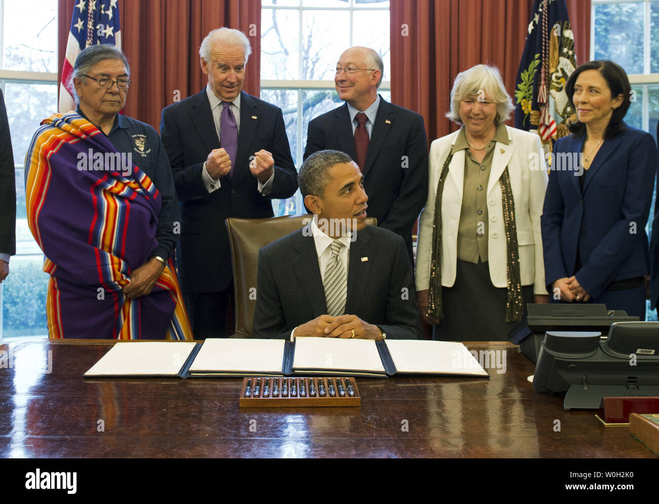 Vice President Joe Biden (2nd-L) jesters as he stands next to Interior Secretary Ken Salazar, prior to President Barack Obama signing a bill designating the First State Monument, in Delaware, a National Monument, during a bill signing ceremony in the Oval Office at the White House on March 25, 2013 in Washington, D.C. President Obama signed a series of bills designating five new National Monuments, including, Rio Grande del Norte, in New Mexico, the First State Monument in Delaware, the Harriet Tubman Underground Railroad in Maryland, the Charles Young Buffalo Soldiers in Ohio and the San Juan Stock Photo