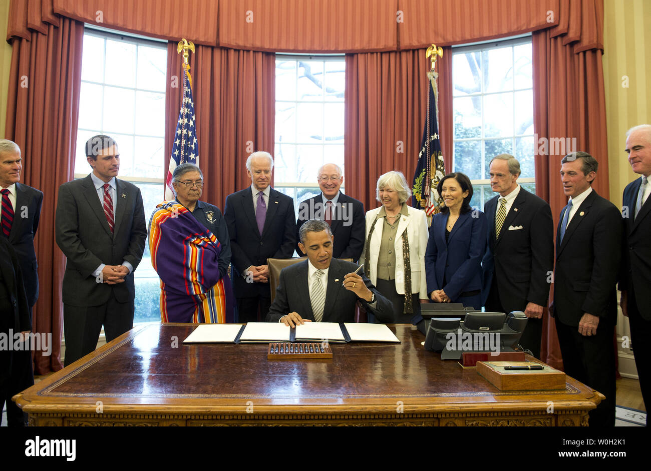 President Barack Obama signs a bill designating Rio Grande del Norte, in New Mexico, a National Monument, during a bill signing in the Oval Office at the White House on March 25, 2013 in Washington, D.C. President Obama signed a series of bills designating five new National Monuments, including, Rio Grande del Norte, in New Mexico, the First State Monument in Delaware, the Harriet Tubman Underground Railroad in Maryland, the Charles Young Buffalo Soldiers in Ohio and the San Juan Islands in Washington. UPI/Kevin Dietsch Stock Photo