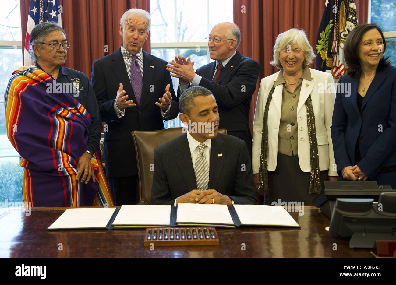 Vice President Joe Biden (2nd-L) jesters as he stands next to Interior Secretary Ken Salazar, prior to President Barack Obama signing a bill designating the First State Monument, in Delaware, a National Monument, during a bill signing ceremony in the Oval Office at the White House on March 25, 2013 in Washington, D.C. President Obama signed a series of bills designating five new National Monuments, including, Rio Grande del Norte, in New Mexico, the First State Monument in Delaware, the Harriet Tubman Underground Railroad in Maryland, the Charles Young Buffalo Soldiers in Ohio and the San Juan Stock Photo