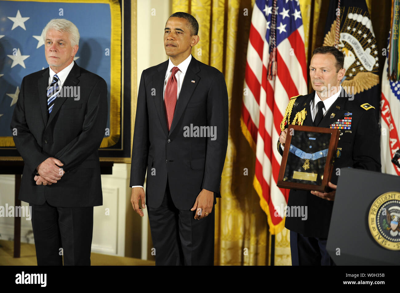 US President Barack Obama (C) and Ray Kapaun, (L), nephew of Father