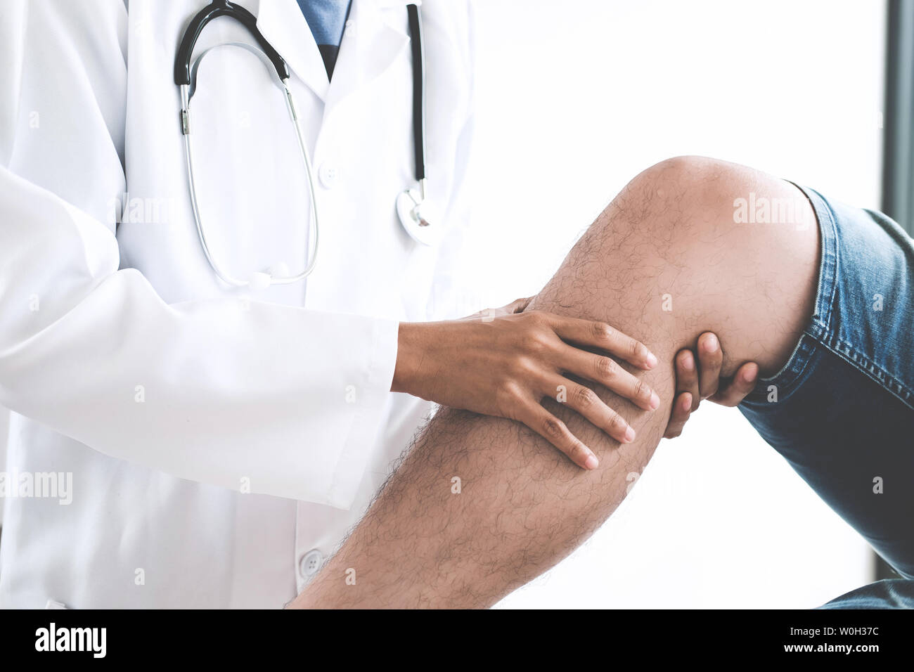 Doctor checking patient with knees to determine the cause of illness. Stock Photo