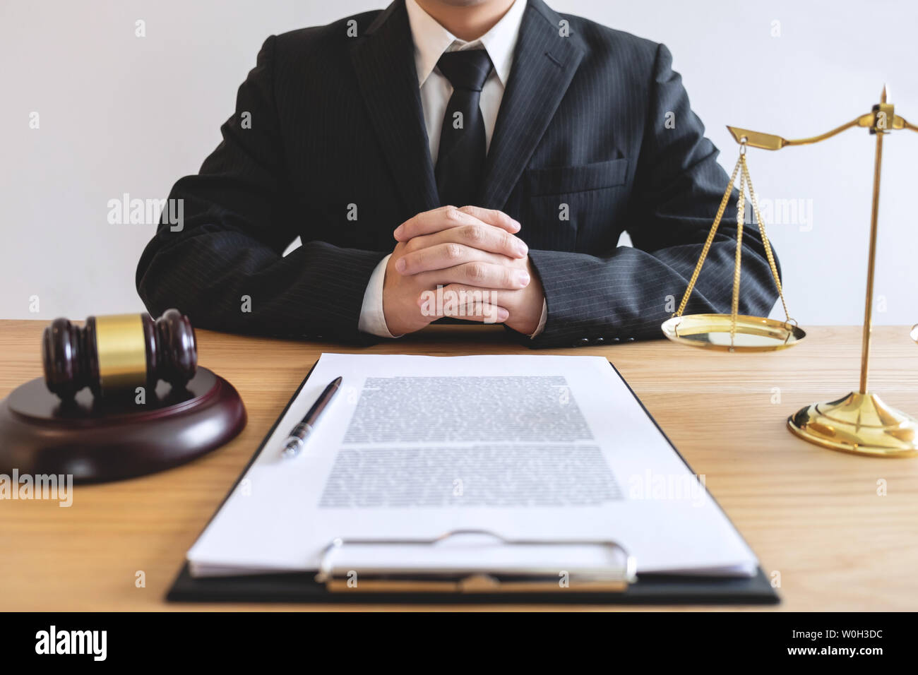 Legal law, advice and justice concept, male lawyer or notary working on a documents and report of the important case and wooden gavel, balance on tabl Stock Photo