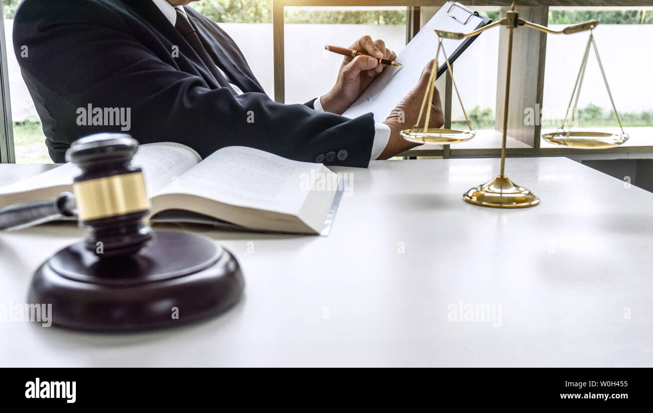 Law, lawyer attorney and justice concept, male lawyer or notary working on a documents and report of the important case in the workplace office. Stock Photo