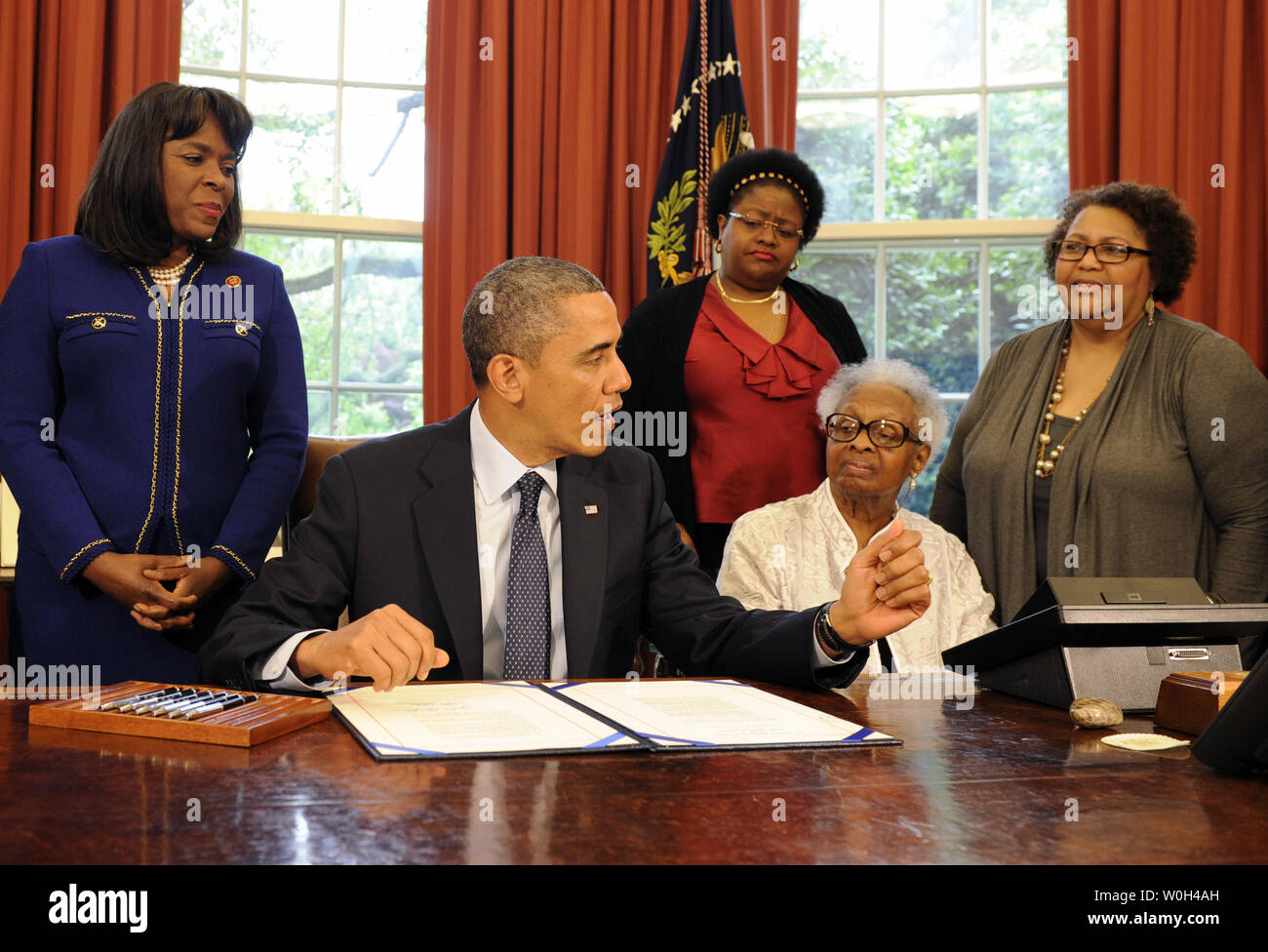 US President Barack Obama makes remarks before he signs a bill in the Oval Office, May 24, 2013 in Washington, DC designating the Congressional Gold Medal commemorating the lives of the four young girls killed in the 16th Street Baptist Church Bombings of 1963 in Birmingham, Alabama. Witnessing (L-R) Rep Terri Sewell (D-AL), Thelma Pippen McNair (mother of Denise McNair), Lisa McNair (sister of Denise McNair), Dianne Braddock (sister of Carole Robertson).            UPI/Mike Theiler.                             . Stock Photo