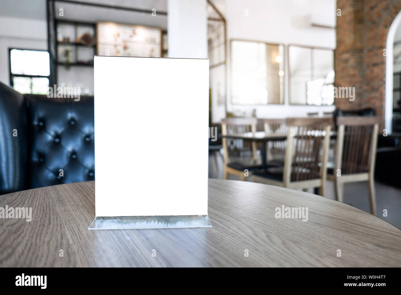 Blank screen mock up menu frame standing on wood table in coffee cafe and restaurant background. Stock Photo